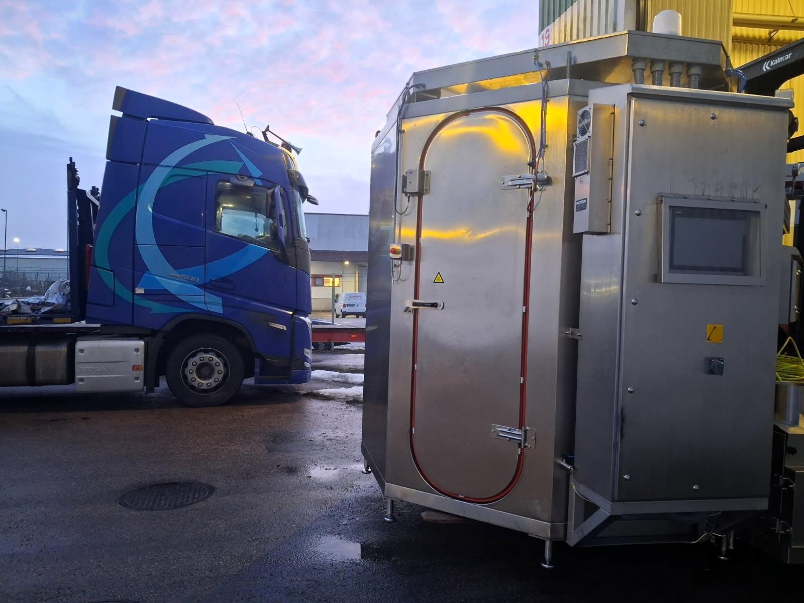 Industrial equipment loaded onto a truck at a logistics terminal, prepared for international road transport