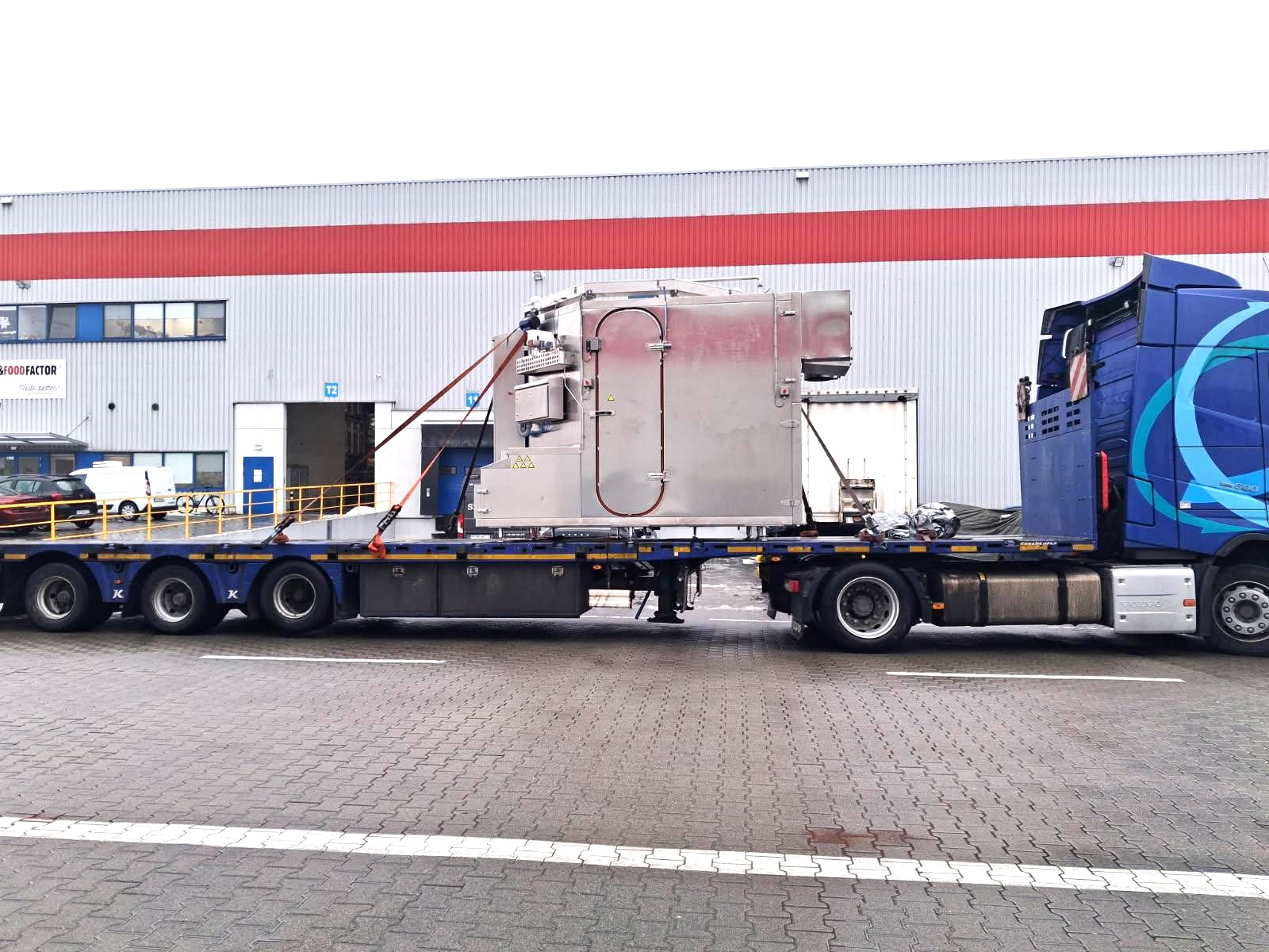 Oversized industrial cargo secured on a flatbed trailer during road transport from Poland.